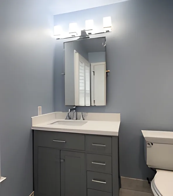 Gray shaker-style vanity with quartz top, medicine cabinet and light bar